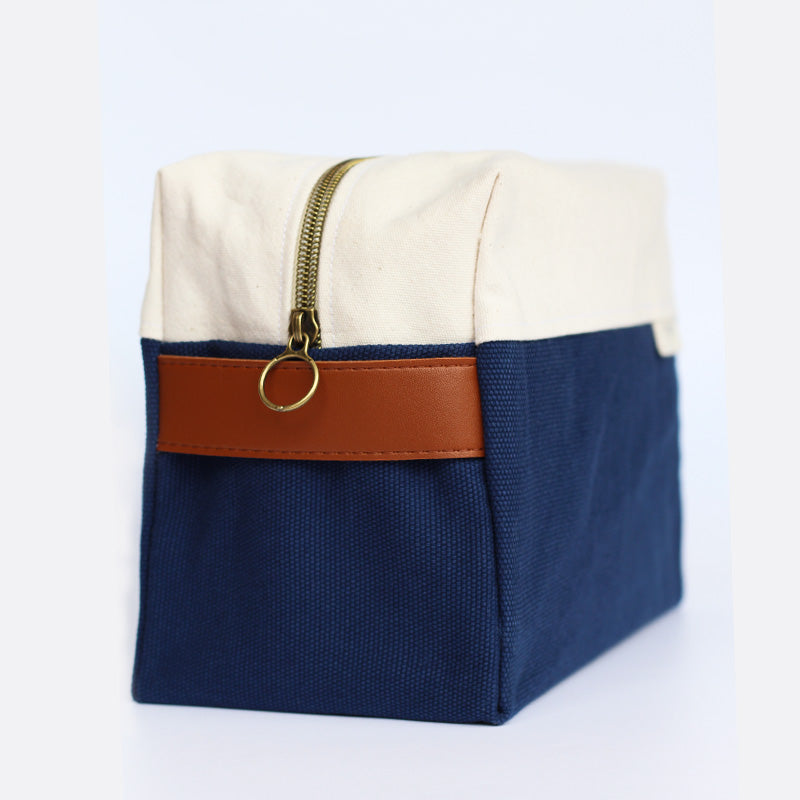 trousse de toilette bleue en tissu avec une fermeture éclair et une poignée en similicuir
