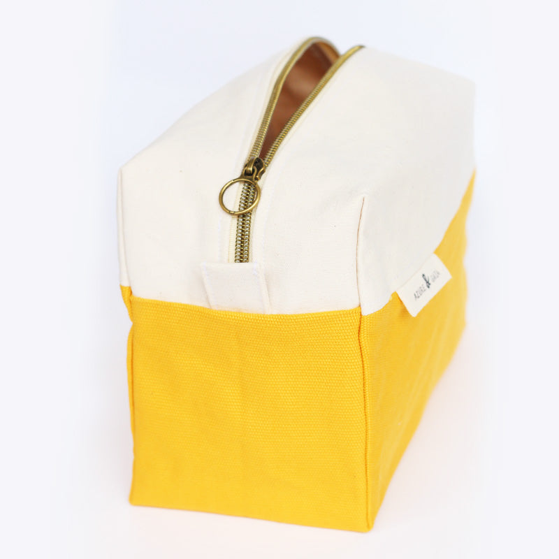 trousse de toilette jaune et crème en tissu avec une fermeture éclair et une poignée en similicuir